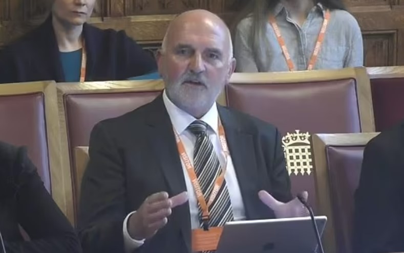 Man in suit speaking at a podium.
