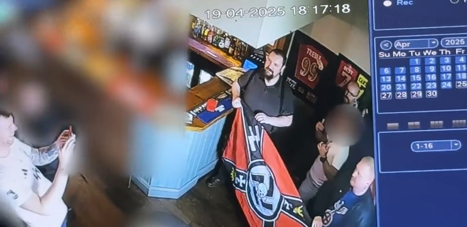 Security camera footage of a man displaying a neo-Nazi flag in a pub.