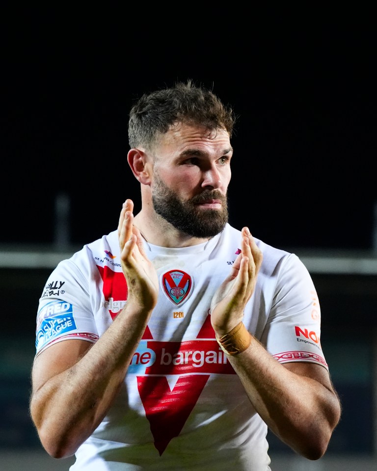 A rugby player in a St. Helens R.F.C. jersey applauds.