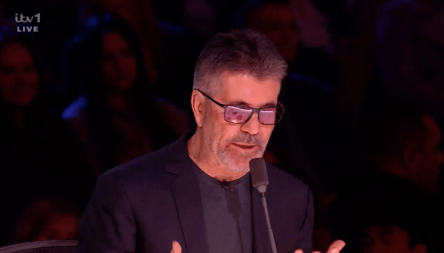 Screenshot of Simon Cowell speaking into a microphone.