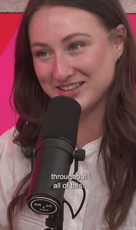 Screenshot of a woman speaking into a microphone.