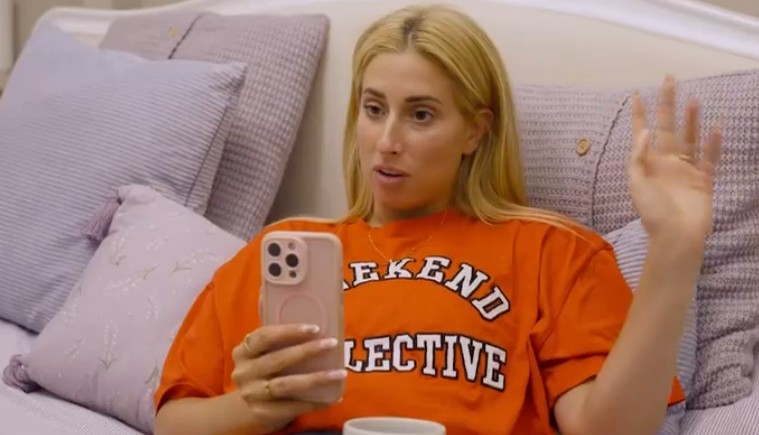 Woman using a smartphone while sitting on a bed.