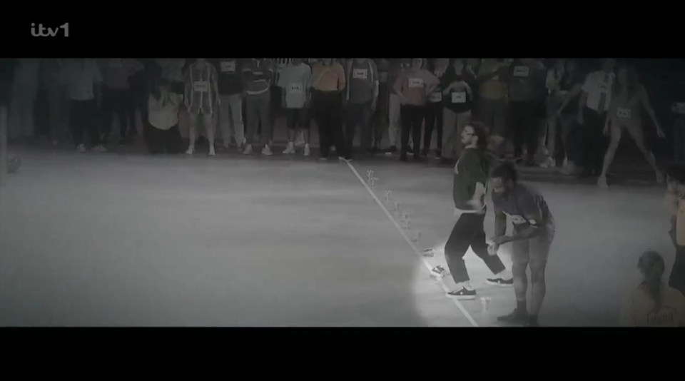 Screenshot of two people dancing while a crowd watches.