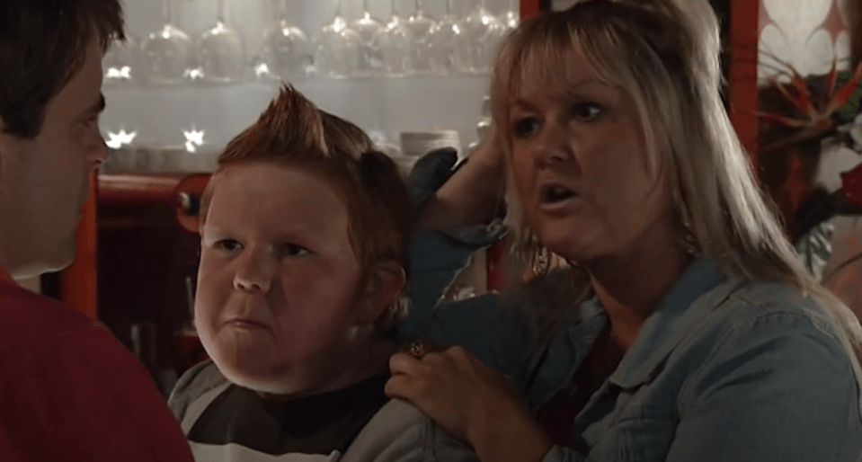 Screenshot of a woman scolding a boy while a man looks on.