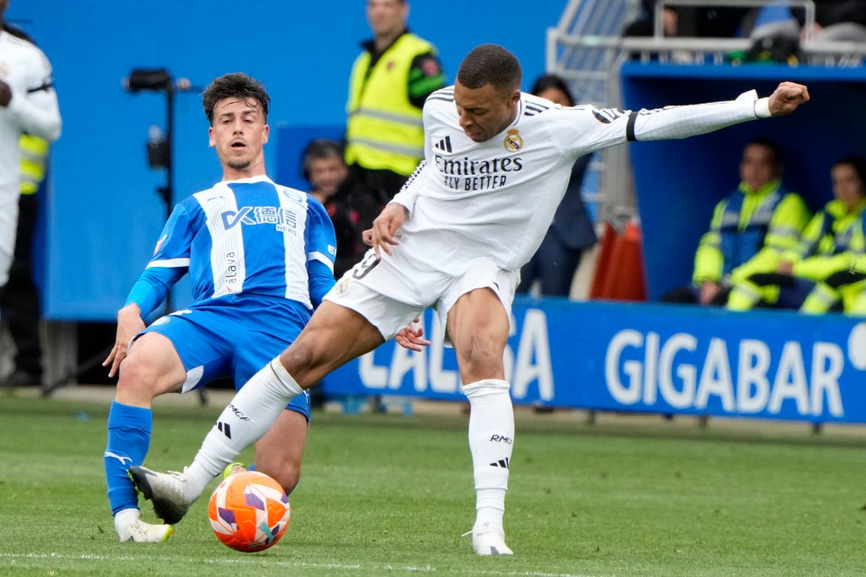 Kylian Mbappé and Antonio Blanco vying for the ball during a soccer match.
