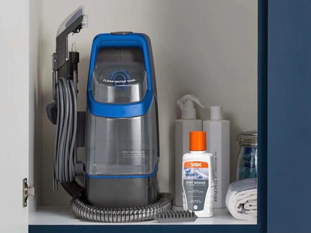 Vax SpotWash Duo spot cleaner in a cupboard.