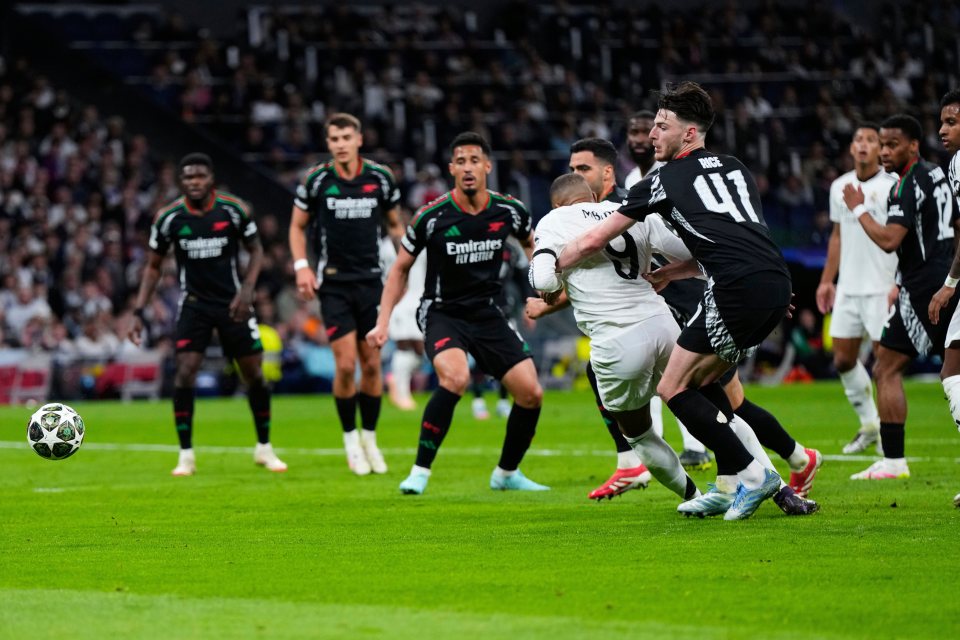 Declan Rice of Arsenal tackling Kylian Mbappé of Real Madrid during a Champions League match.