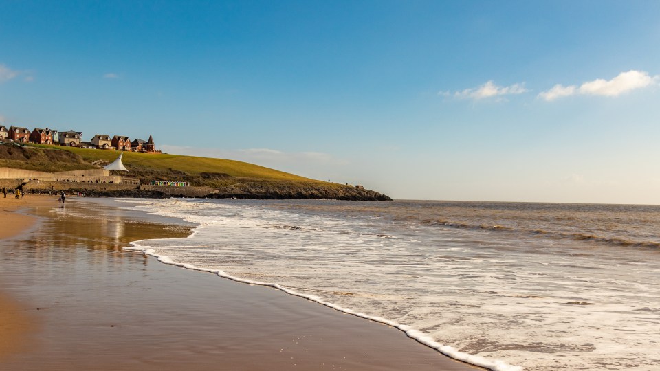 Barry Island beach with houses on a hill in the background.