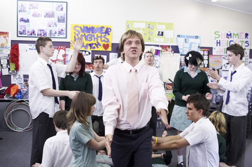 Mr. G from Summer Heights High surrounded by students.