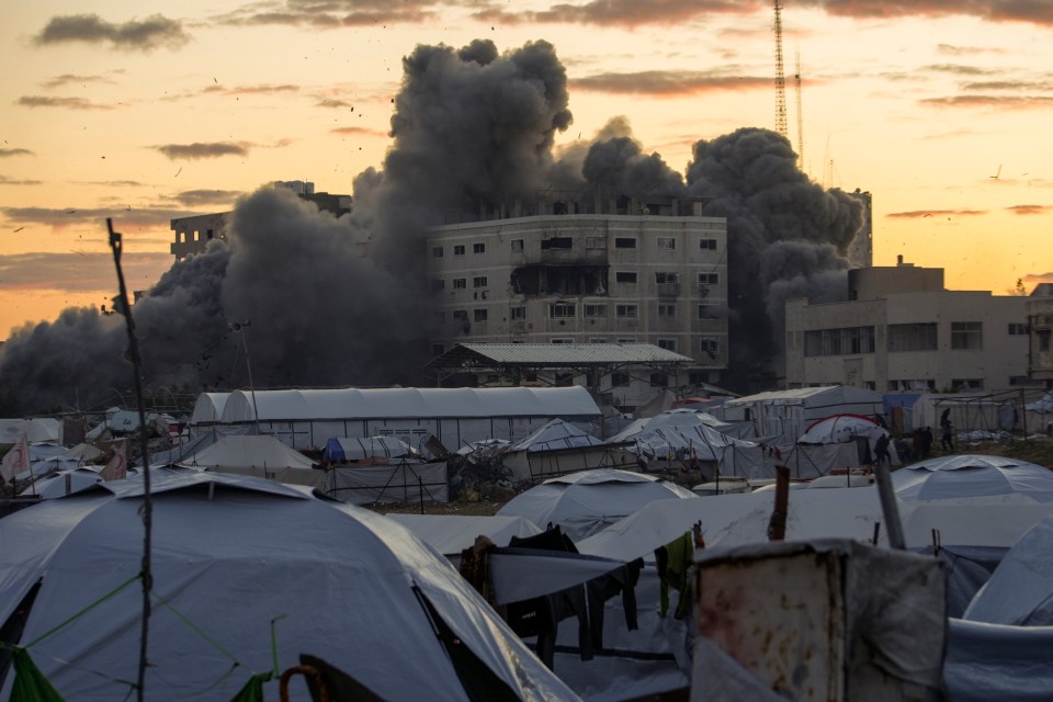 Smoke rises from a building hit by an Israeli army strike near a tent camp for displaced Palestinians in Gaza City.