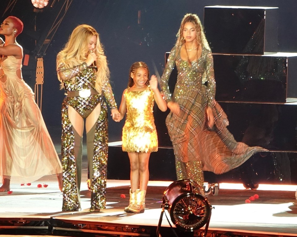 Beyoncé, Blue Ivy Carter, and Rumi Carter onstage during a concert.