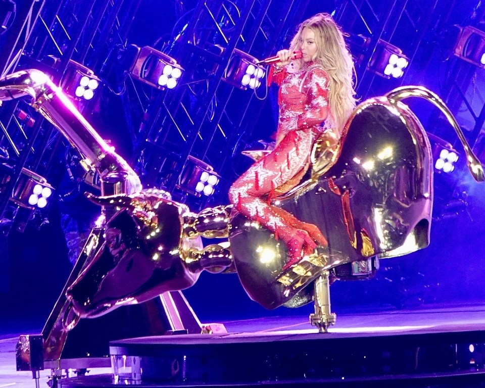 Beyoncé performing on a golden bull at a concert.