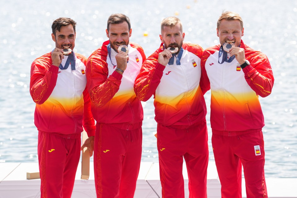 Spanish men's kayak four team showing off their bronze medals at the Olympics.