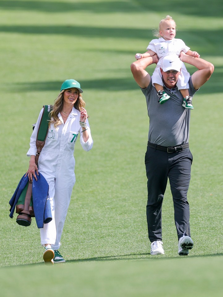 Brooks Koepka walking with his wife and son.