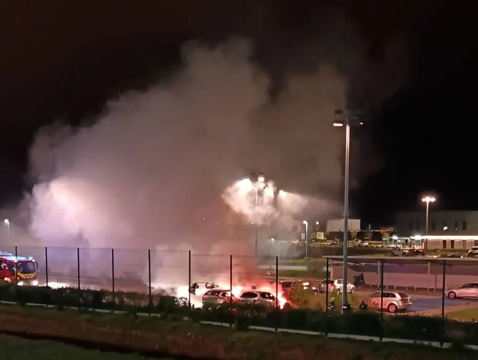 Burning cars and smoke at night.
