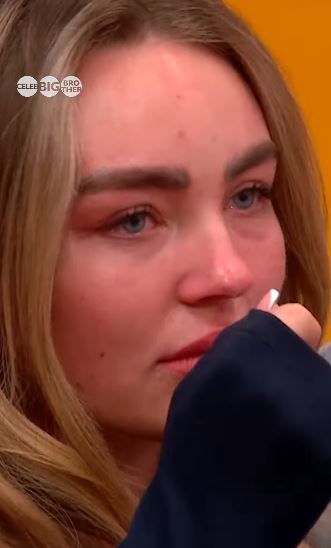 Close-up of a blonde woman crying.