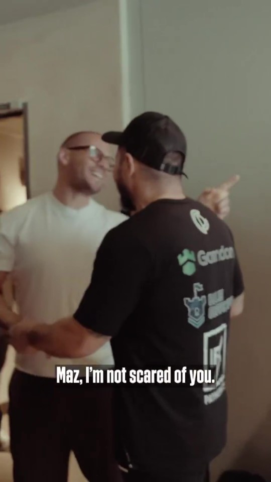 Two men confronting each other, one saying, "Maz, I'm not scared of you."
