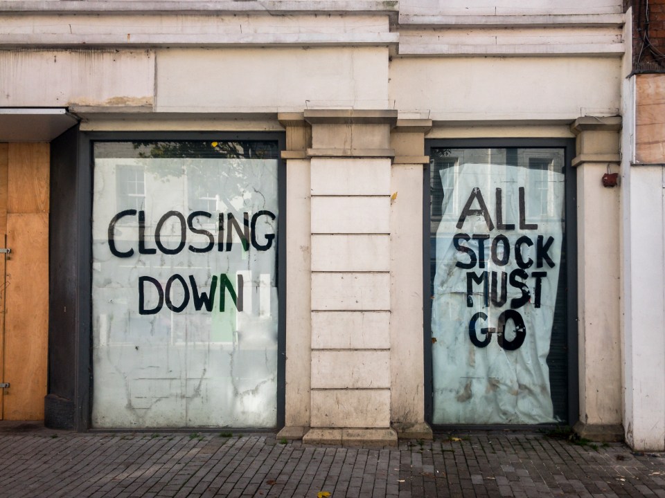 Closed shop windows with "Closing Down" and "All Stock Must Go" signs.