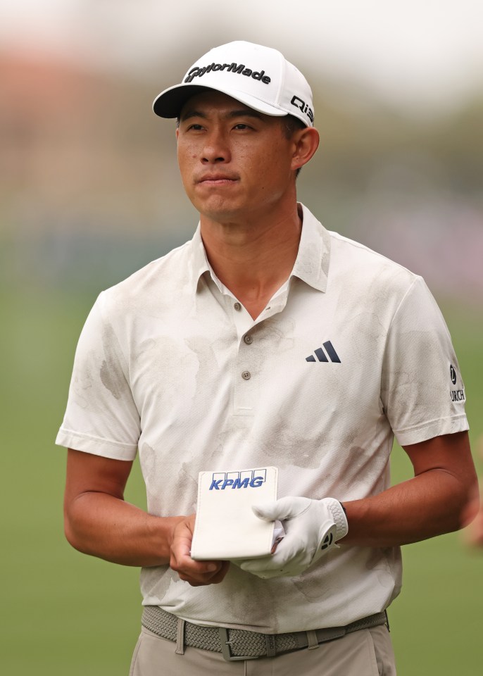 Collin Morikawa looking at his yardage book.