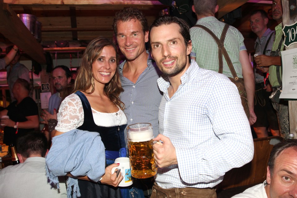 Three people at Oktoberfest, holding beer steins.