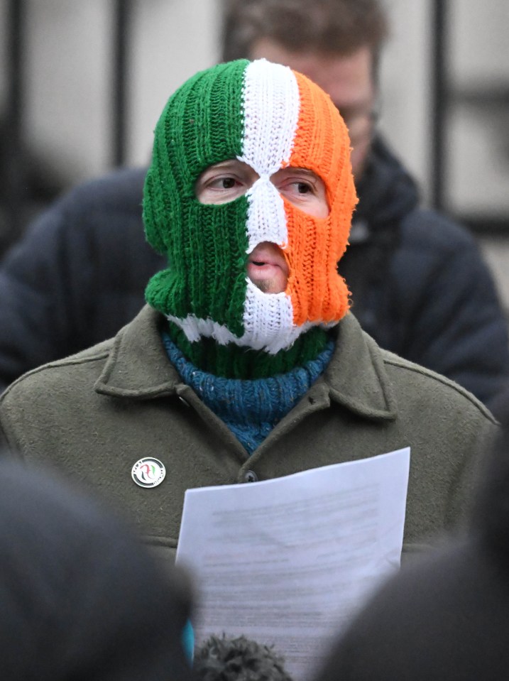A member of the Northern Irish rap group Kneecap, wearing a balaclava with Irish colors, at the Royal Courts of Justice in Belfast.