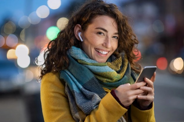 Woman using smartphone outdoors at night.