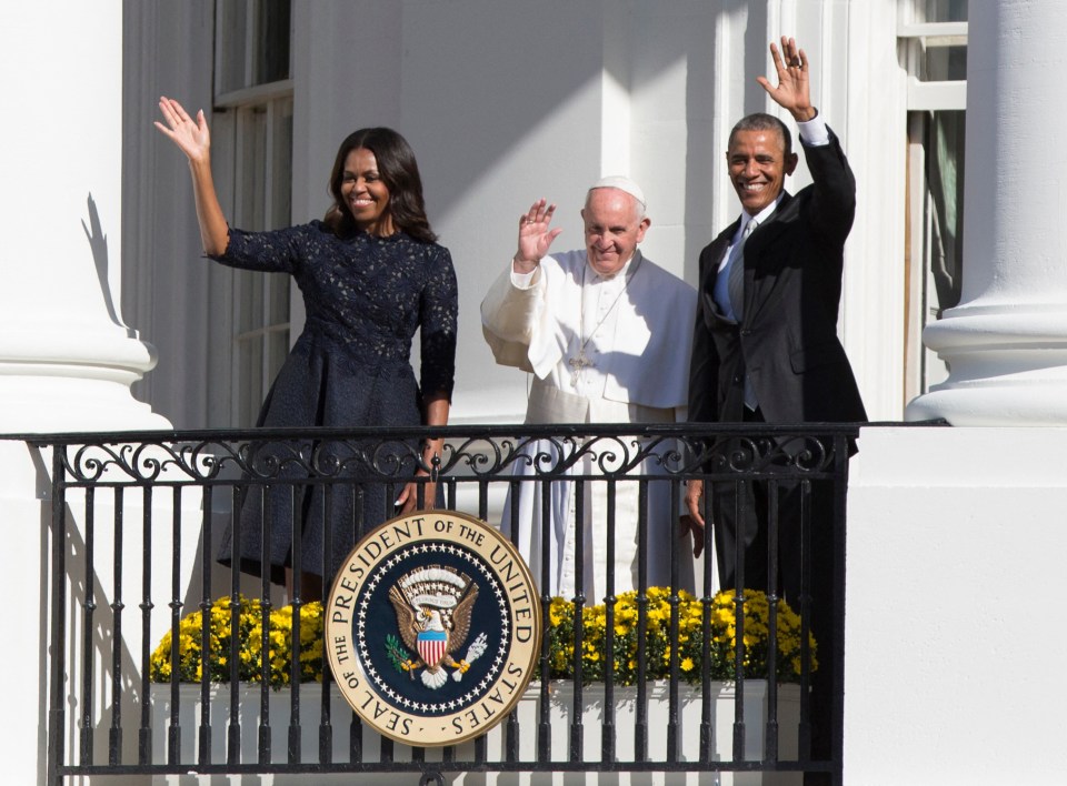 Pope Francis and other officials on a balcony, waving.