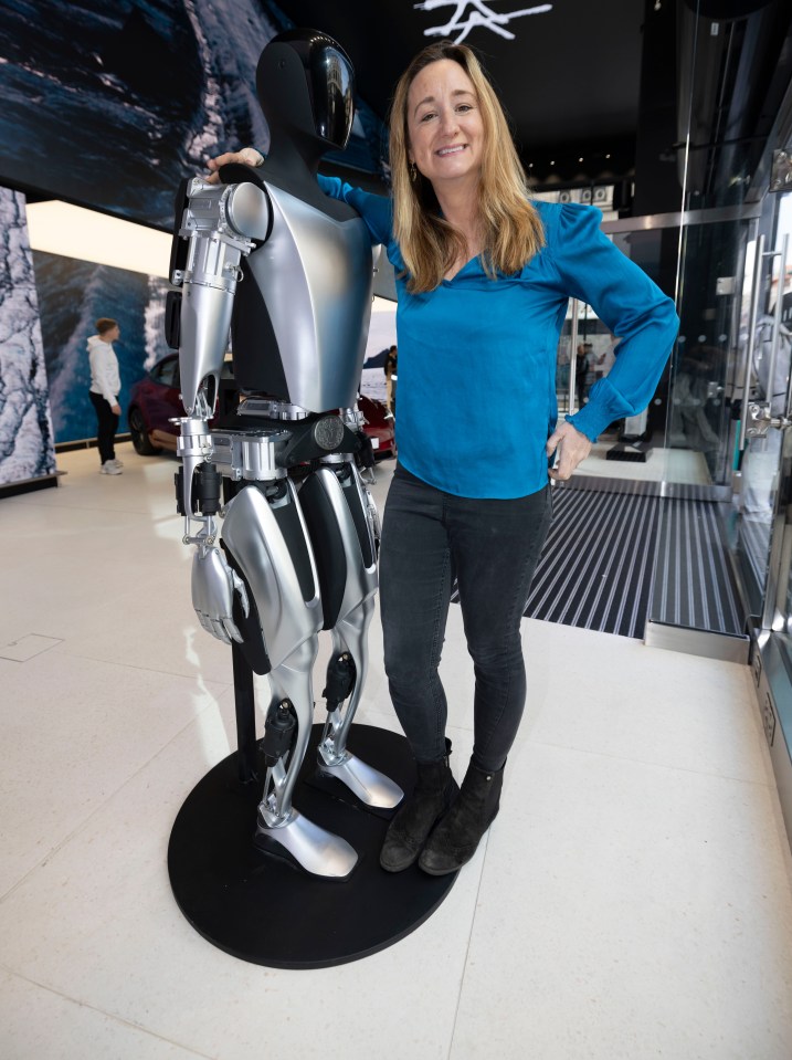 Woman standing next to a robot.