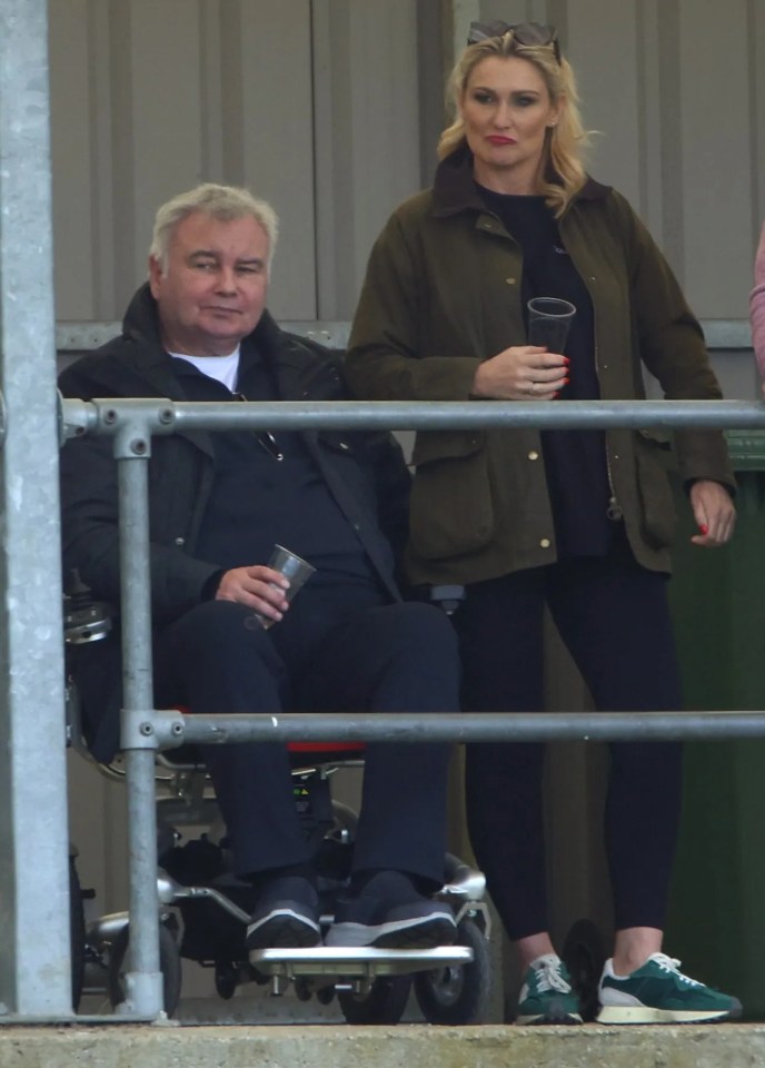 A man in a wheelchair and three other people watching a sporting event.