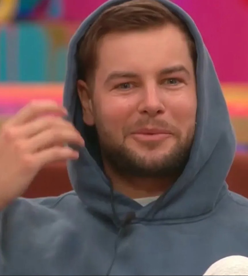 Man in a blue hoodie smiling.