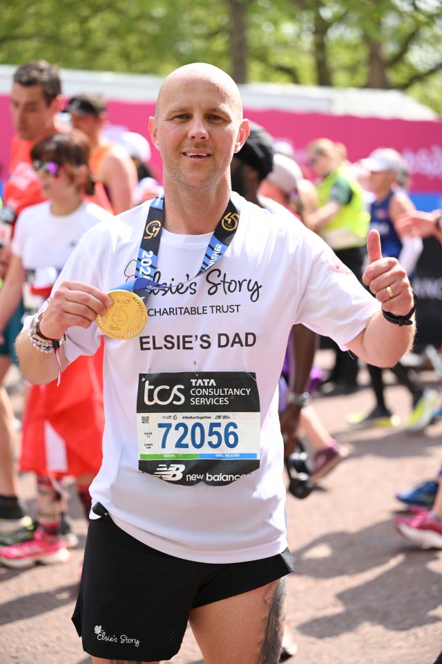 Runner holding a medal after completing the London Marathon.