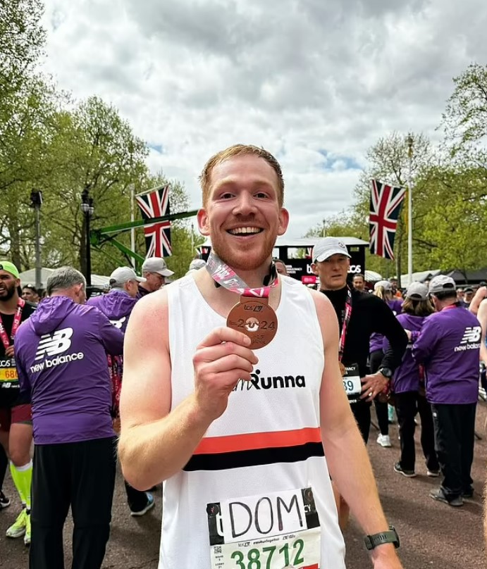 Runner holding a bronze medal at a marathon.