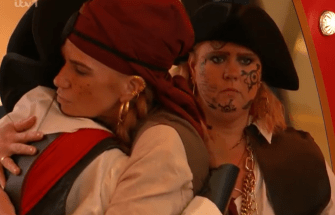 Two women in pirate costumes embracing.