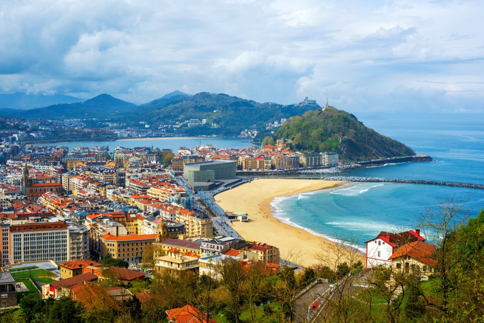 Aerial view of San Sebastian, Spain, showing the beach, city, and surrounding mountains.