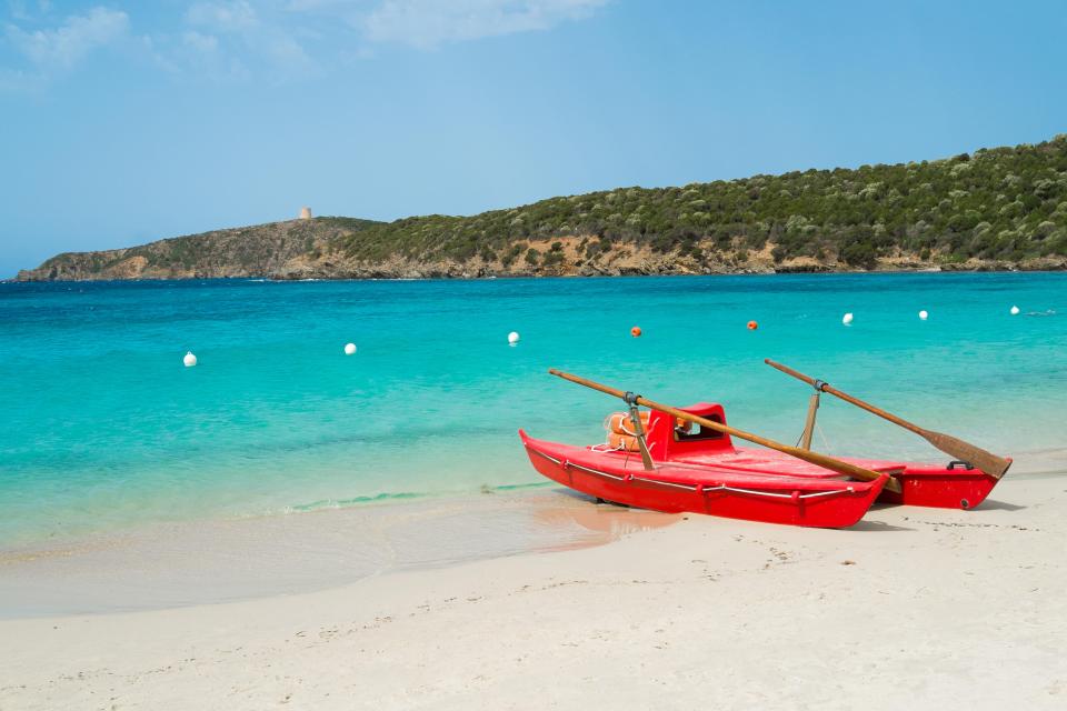 Red rescue boat on a sandy beach.