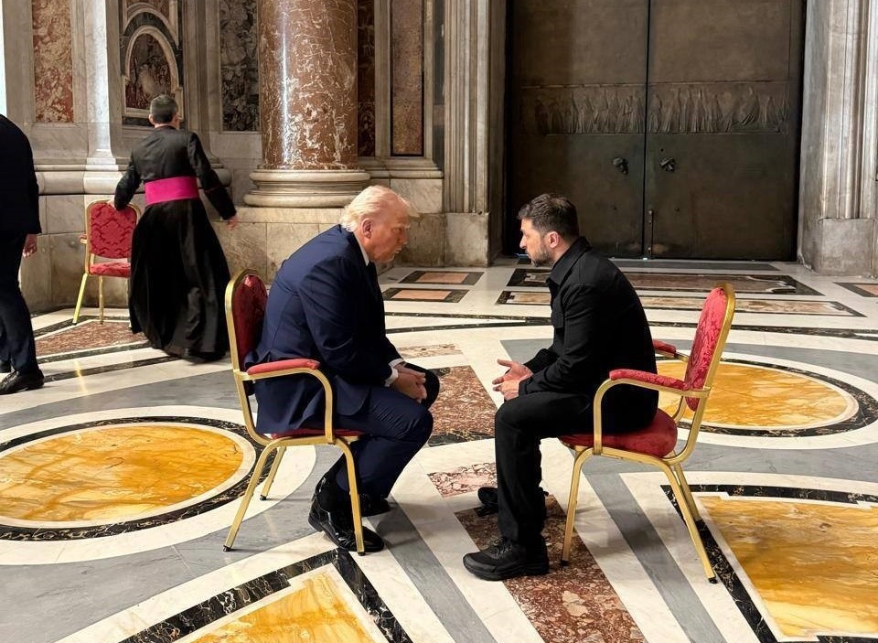 President Biden and a man seated in chairs, in conversation.