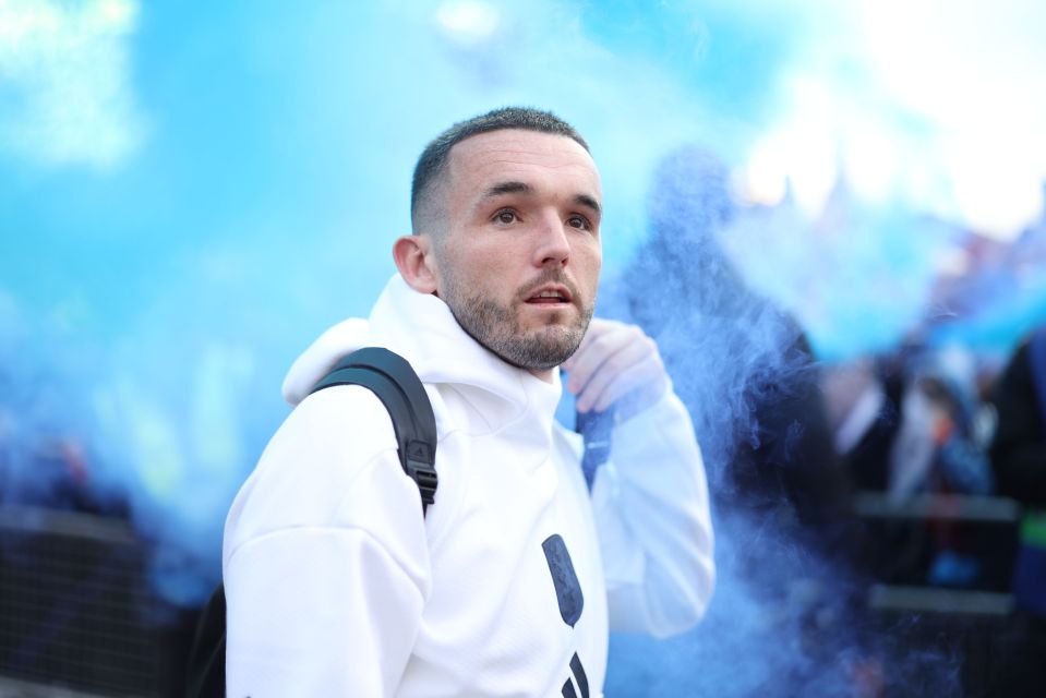 John McGinn of Aston Villa amidst blue smoke.