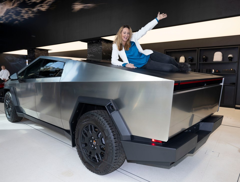 Woman lying on the hood of a Tesla Cybertruck.