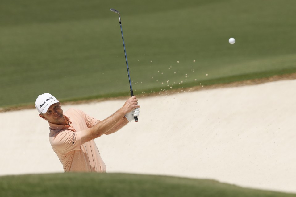 Justin Rose hitting a golf ball out of a sand trap.