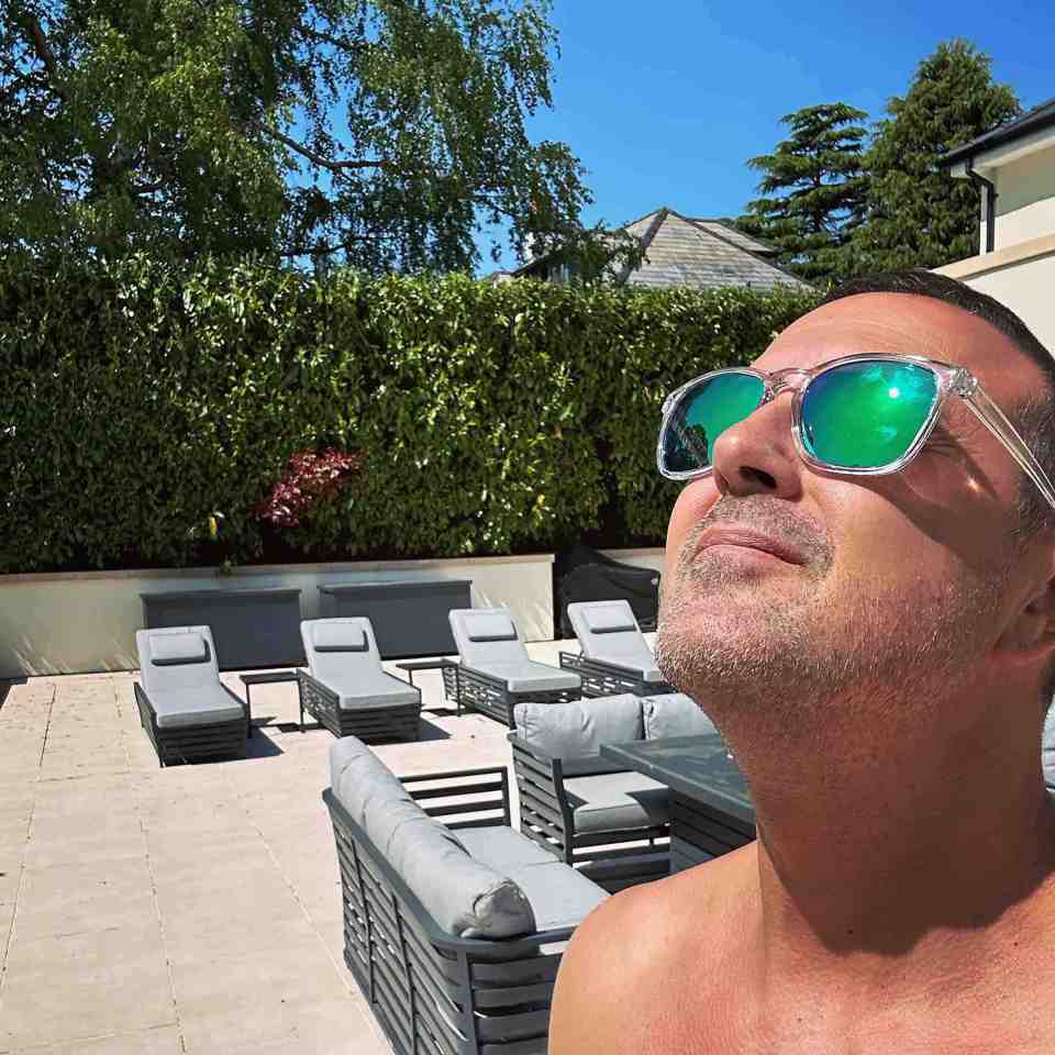 Man in sunglasses enjoying the sun by a pool.