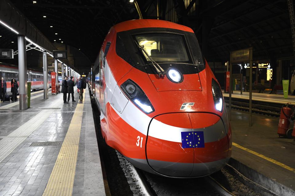 Red high-speed train at a station.