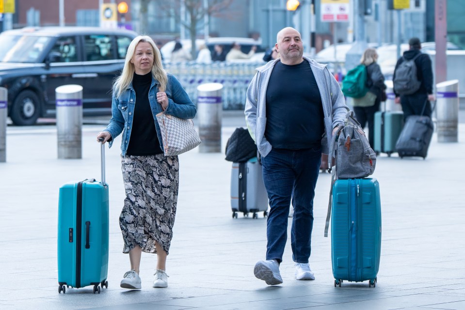 Wynne Evans and Liz Brookes at an airport, pulling suitcases.