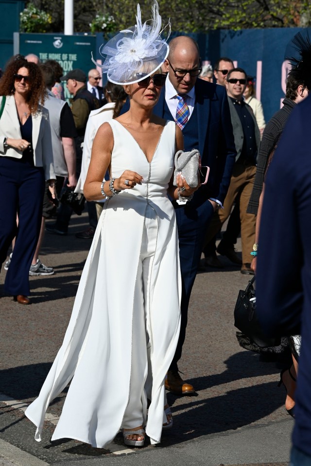 Woman in white jumpsuit and hat at Aintree Grand National Festival.