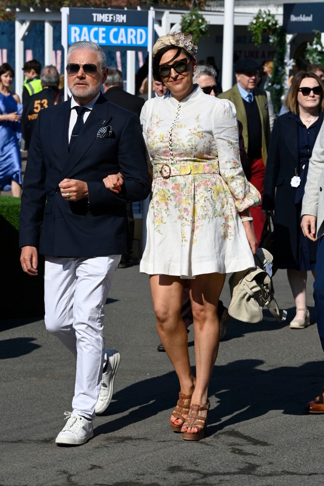Couple in fashionable attire at the Aintree Grand National Festival.