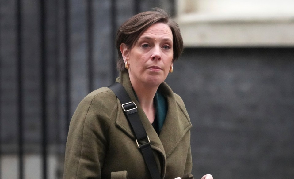 Jess Phillips, UK Parliamentary Under-Secretary of State for Safeguarding and Violence Against Women and Girls, using a mobile phone.