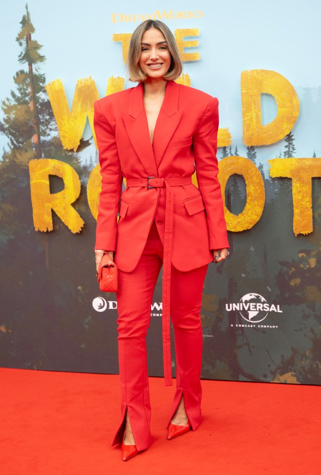 Frankie Bridge at the premiere of The Wild Robot, wearing a red pantsuit.