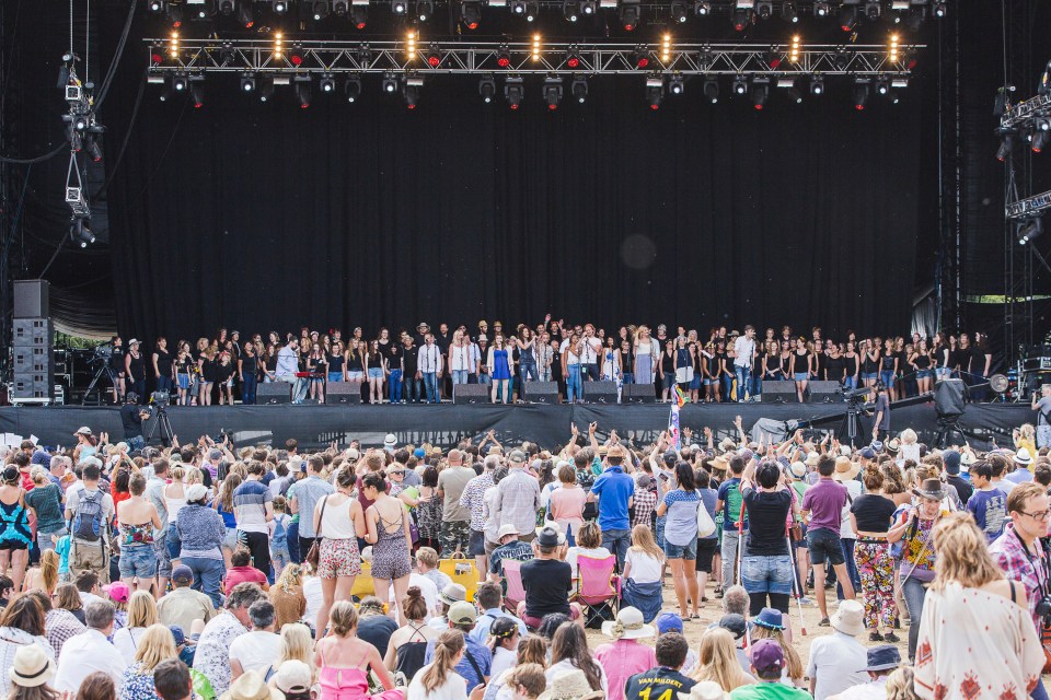 Gareth Malone and the Latitude Choir performing on stage at a music festival.