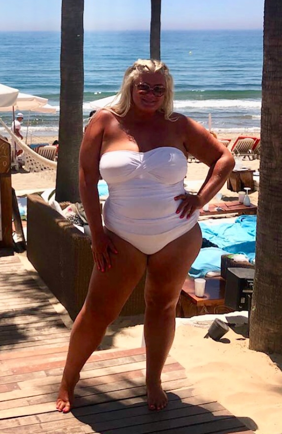 Gemma Collins in a white swimsuit on a beach.