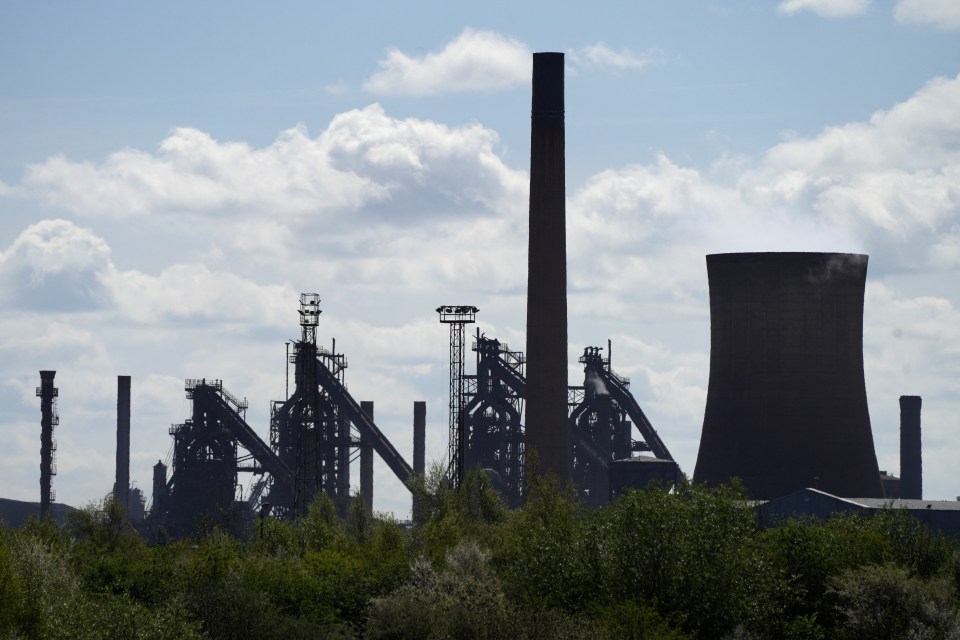 Silhouette of blast furnaces and industrial structures at a steel plant.