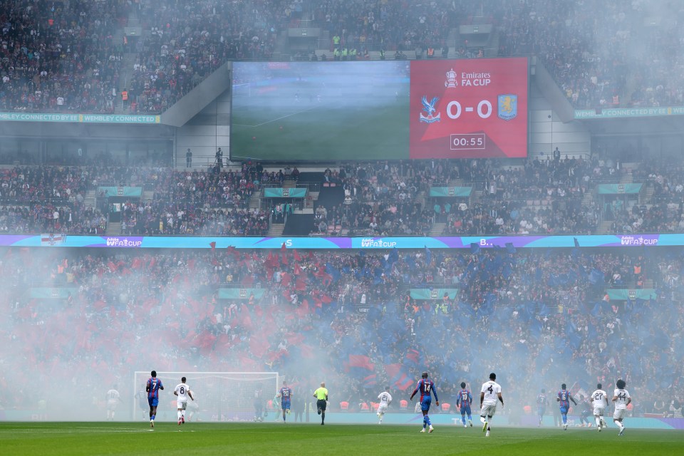Smoke drifts across a soccer field at Wembley Stadium during a Crystal Palace and Aston Villa match.